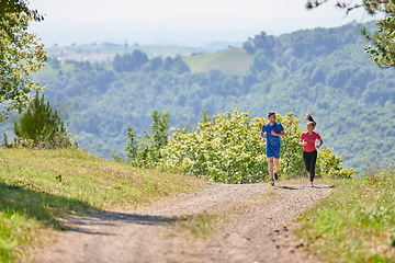 Image showing couple enjoying in a healthy lifestyle while jogging on a country road