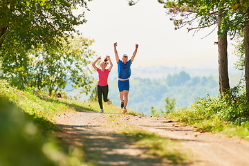 Image showing couple enjoying in a healthy lifestyle while jogging on a country road