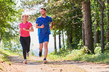 Image showing couple enjoying in a healthy lifestyle while jogging on a country road