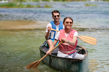 Image showing friends are canoeing in a wild river