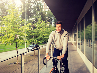 Image showing young man riding bicycle on city street