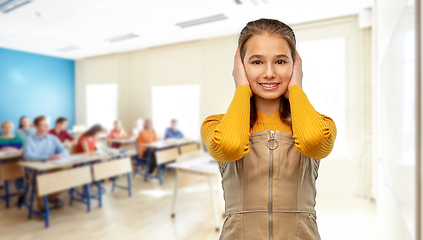 Image showing student girl closing ears by hands at school