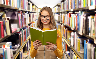 Image showing student girl in glasses reading book at library