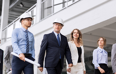 Image showing business team in helmets walking along office