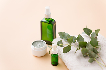 Image showing serum, clay mask, oil and eucalyptus on bath towel