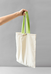 Image showing hand holding reusable canvas bag for food shopping