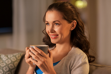 Image showing happy woman drinking tea or coffee at home