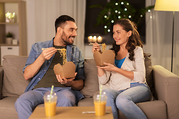 Image showing happy couple eating takeaway noodles at home