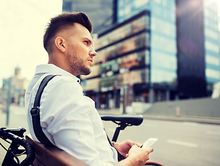 Image showing man with smartphone and bicycle in city