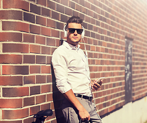 Image showing man with headphones, smartphone and bicycle