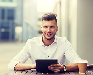 Image showing man with tablet pc and coffee at city cafe