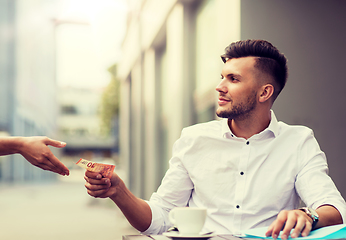 Image showing man with euro money paying for coffee at cafe