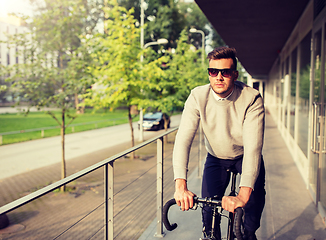 Image showing young man riding bicycle on city street