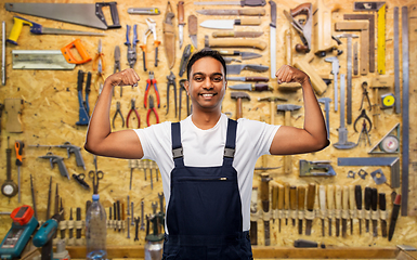 Image showing smiling indian worker or builder showing his power