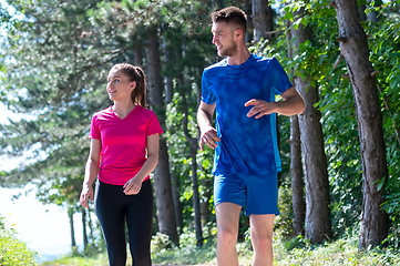 Image showing couple enjoying in a healthy lifestyle while jogging on a country road