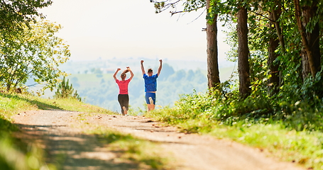 Image showing couple enjoying in a healthy lifestyle while jogging on a country road