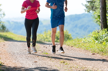 Image showing couple enjoying in a healthy lifestyle while jogging on a country road