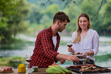 Image showing friends having picnic french dinner party outdoor during summer holiday