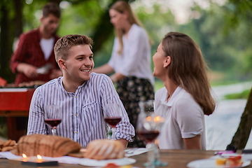 Image showing friends having picnic french dinner party outdoor during summer holiday