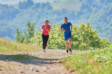 Image showing couple enjoying in a healthy lifestyle while jogging on a country road