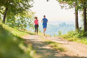 Image showing couple enjoying in a healthy lifestyle while jogging on a country road