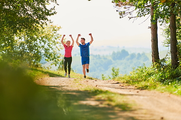 Image showing couple enjoying in a healthy lifestyle while jogging on a country road