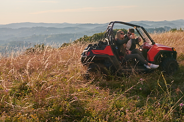 Image showing couple enjoying beautiful sunny day taking selfie picture while driving a off road buggy