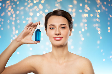 Image showing beautiful young woman with bottle of serum