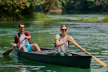 Image showing friends are canoeing in a wild river