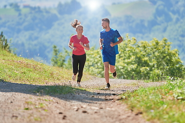 Image showing couple enjoying in a healthy lifestyle while jogging on a country road