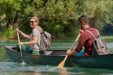 Image showing friends are canoeing in a wild river