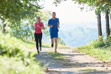 Image showing couple enjoying in a healthy lifestyle while jogging on a country road