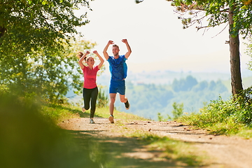 Image showing couple enjoying in a healthy lifestyle while jogging on a country road