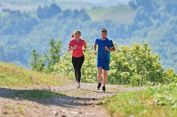 Image showing couple enjoying in a healthy lifestyle while jogging on a country road