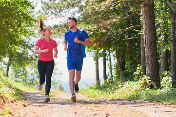 Image showing couple enjoying in a healthy lifestyle while jogging on a country road