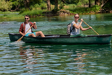 Image showing friends are canoeing in a wild river