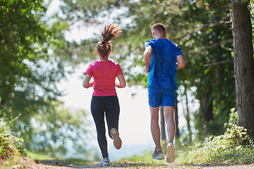 Image showing couple enjoying in a healthy lifestyle while jogging on a country road