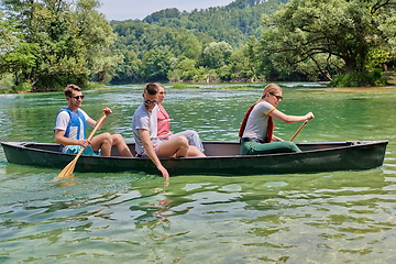 Image showing Group adventurous explorer friends are canoeing in a wild river