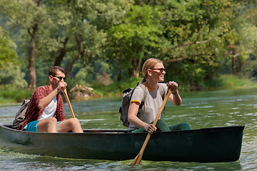 Image showing friends are canoeing in a wild river