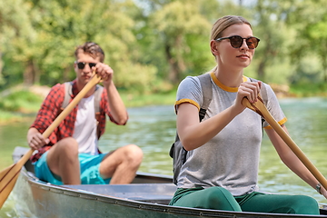 Image showing friends are canoeing in a wild river