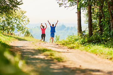 Image showing couple enjoying in a healthy lifestyle while jogging on a country road