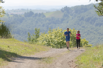 Image showing couple enjoying in a healthy lifestyle while jogging on a country road