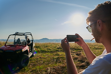 Image showing cameraman recording a young couple enjoying a buggy car ride up a mountain