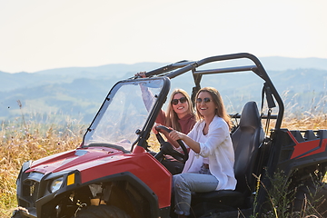 Image showing girls enjoying a beautiful sunny day while driving an off-road car