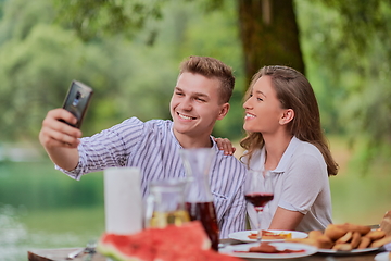 Image showing couple taking selfie while having picnic french dinner party outdoor