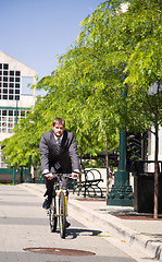 Image showing Caucasian businessman riding a bicycle