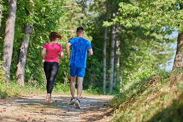 Image showing couple enjoying in a healthy lifestyle while jogging on a country road