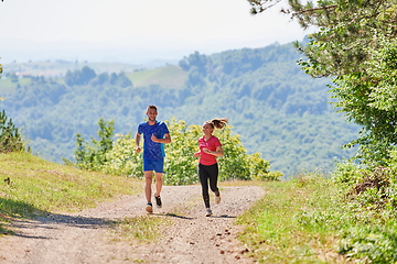 Image showing couple enjoying in a healthy lifestyle while jogging on a country road