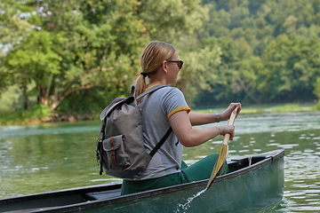 Image showing woman adventurous explorer are canoeing in a wild river