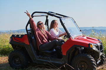 Image showing girls enjoying a beautiful sunny day while driving an off-road car